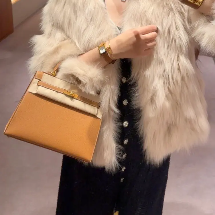Elegant model carrying Replica Hermes Kelly 25cm Gold Epsom bag