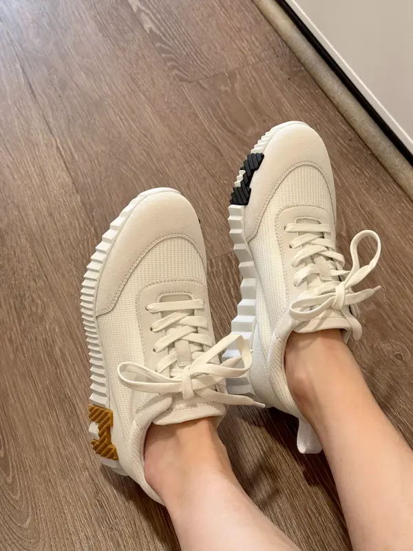 Woman wearing white replica Hermes Bouncing sneakers with jeans outfit