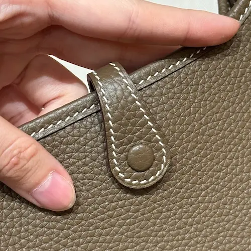 Button closure mechanism on back of Hermes Evelyne 16 replica bag