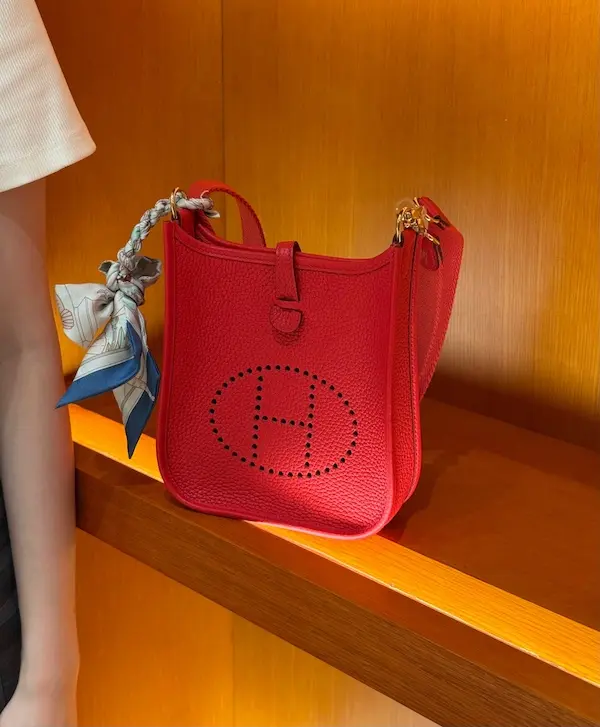 Front view of red Clemence leather Hermes Evelyne replica bag