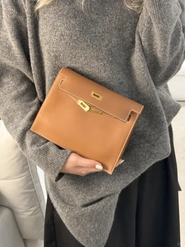 Evening Look: Gold Hermes Kelly Danse Replica in Clutch Mode Close-up of hand carrying Golden Brown Hermes Kelly Danse replica as clutch