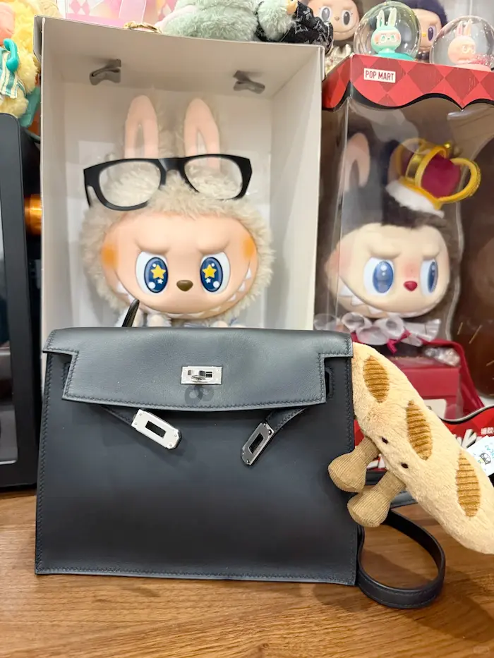 What Fits Inside: Replica Kelly Danse Daily Essentials Test Capacity demonstration: Black Hermes Kelly Danse replica holding full-size wallet, phone and makeup pouch