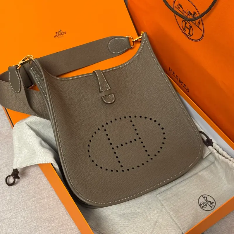 Unboxed Etoupe grey replica Hermes Evelyne 29 showing interior details and strap