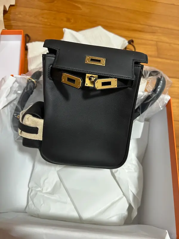 Side profile view of the Black Hermes Kelly Jump Backpack Replica showcasing its structure