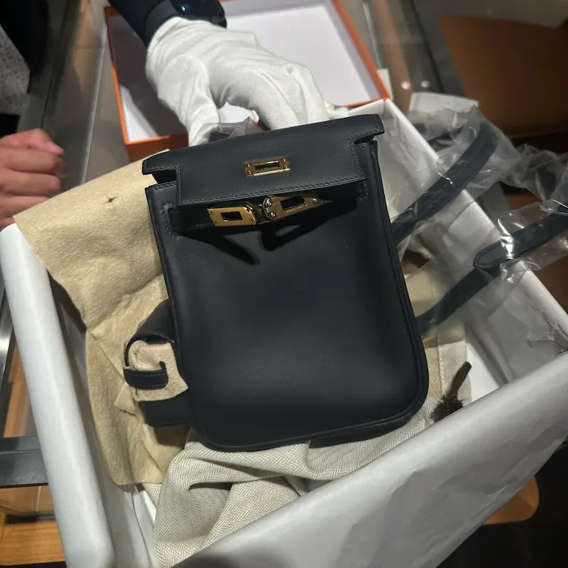 Front view of the Replica Hermes Kelly Jump Backpack in Black with toggle closure visible