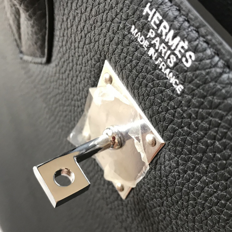 Rear view of black 50cm Replica Handbag Store replica showing back pocket and heat-stamped branding