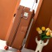 Replica Hermes R.M.S Cabin Suitcase in Gold shown in luxury travel setting.
